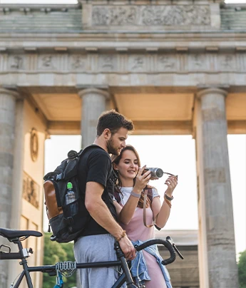 Pareja viendo fotos en una cámara en destino Alemania. Teduca estudios en el exterior.