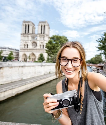 Mujer sonriendo con una cámara, Destino Francia. Teduca estudios en el exterior.